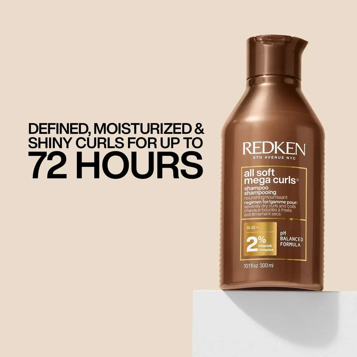 Redken All Soft Mega Curls Shampoo 300 ml bottle in a metallic bronze-brown color, displayed on a white pedestal against a beige background with promotional text.