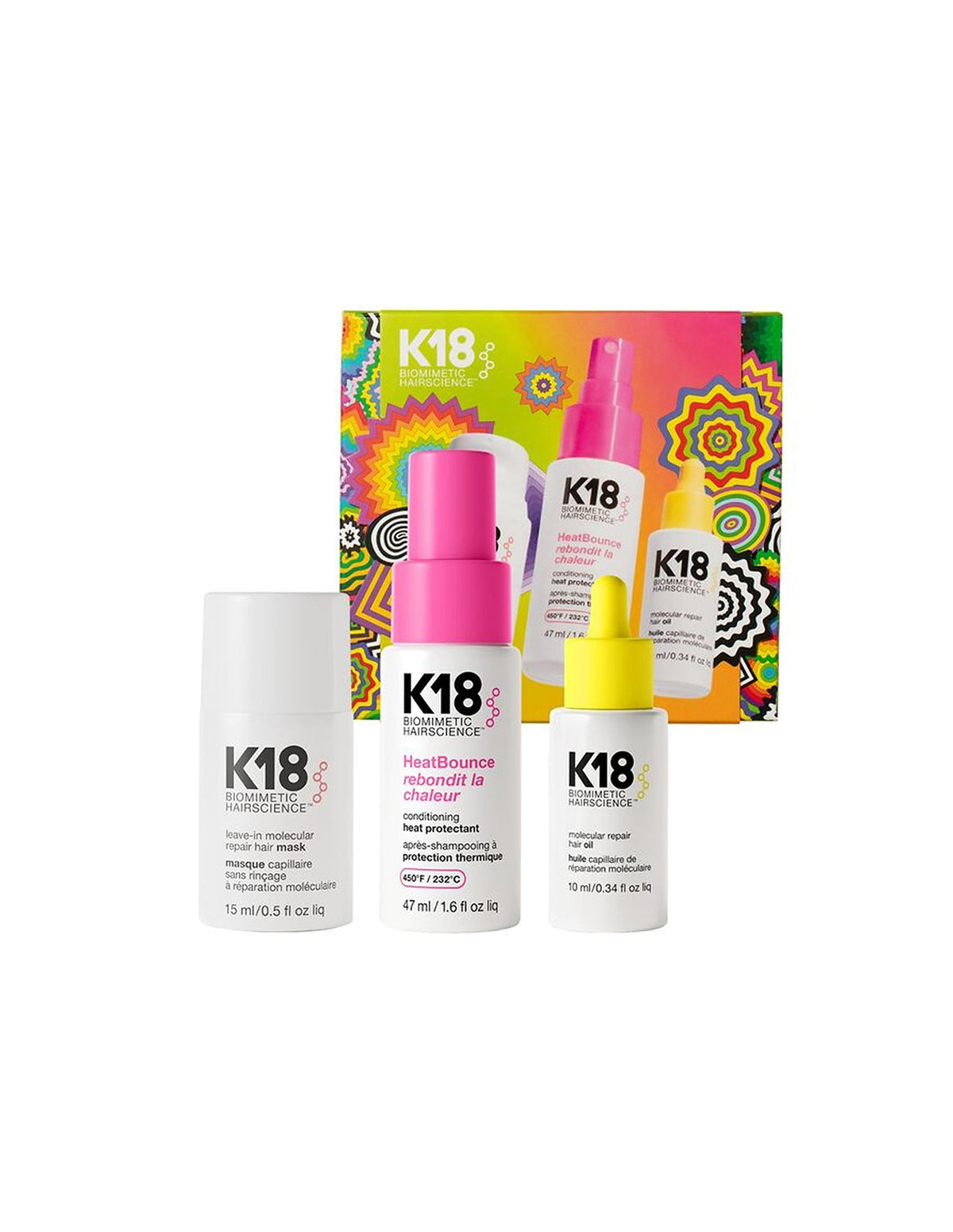 K18 Haircare hair care set featuring a white hair mask bottle, a white hair growth spray bottle with a pink cap, and a white hair growth booster bottle with a yellow cap, displayed in front of their colorful patterned packaging box on a white background.