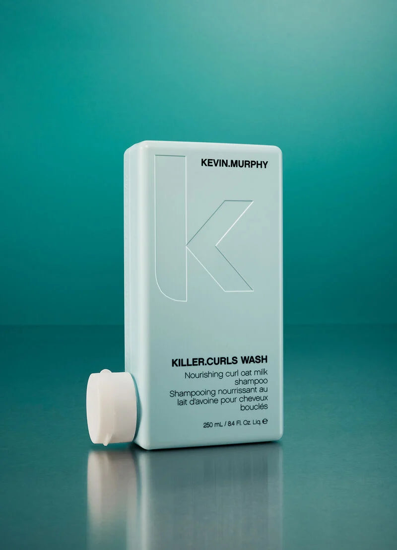 Kevin Murphy Killer Curls Wash in a light blue rectangular bottle with a white cap, set against a teal gradient background.