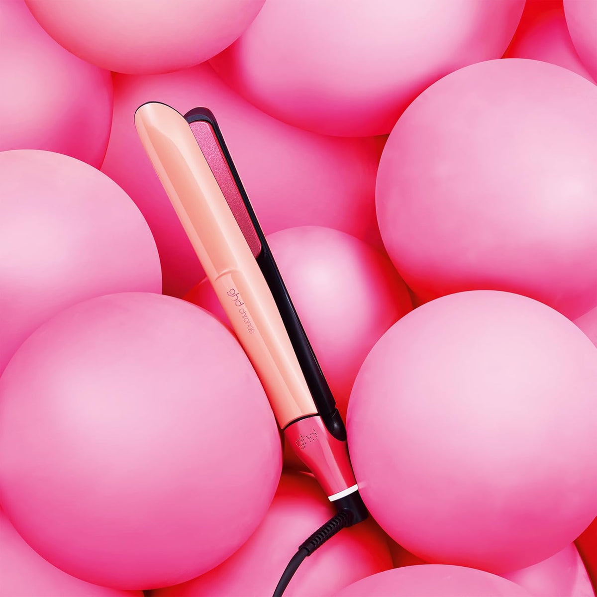 Hair straightener on a bed of pink balloons