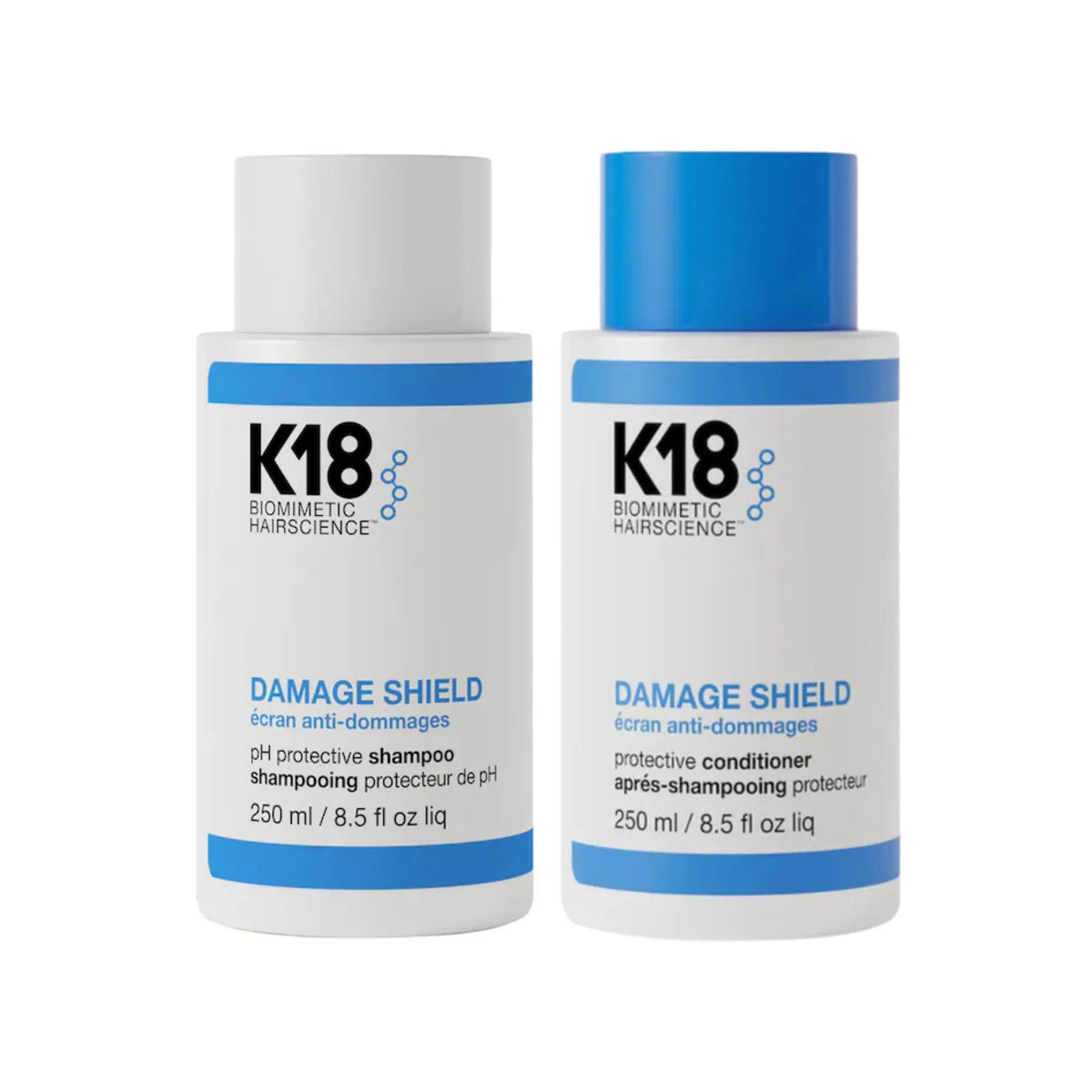 Two bottles of K18 hair care products, one labeled as 'DAMAGE SHIELD pH protective shampoo' and the other as 'DAMAGE SHIELD protective conditioner'. Both have a white body with blue and blue-green labeling.
