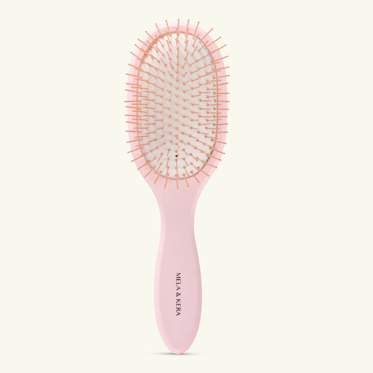 Pink hairbrush with 'Mila & Kera' branding on a white background