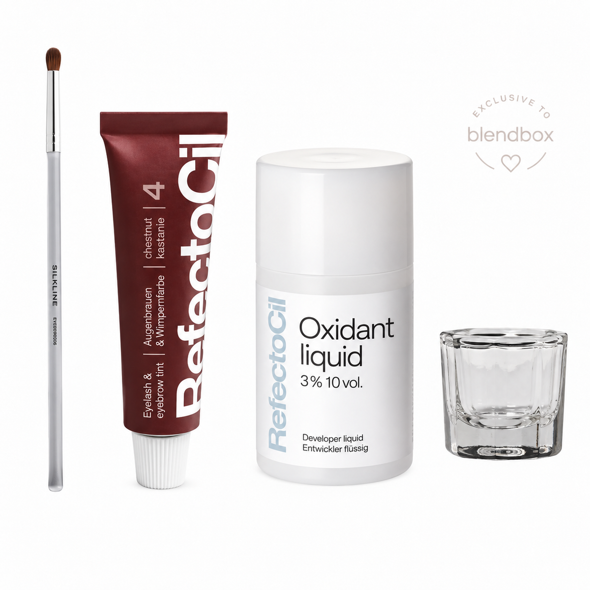 A beauty product set on a white background, including a brown eyeshadow brush, a tube of RefectoSil 4 Eyeshadow & Eyebrow Ink, a white bottle of RefectoSil Oxidant Liquid 3% 10 vol., and a small clear glass mixing cup.