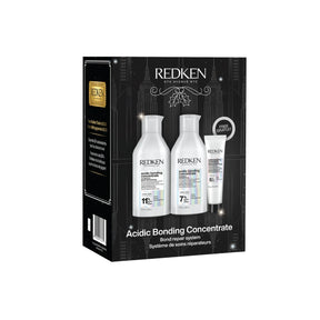 Redken Acidic Bonding Concentrate gift set in a black box, featuring three white bottles and a white tube of hair repair products.