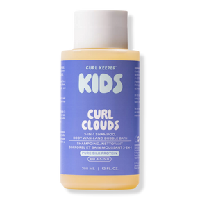 A bottle of Curl Keeper Kids Curl Clouds 3-in-1 shampoo, body wash, and bubble bath. The product features a light purple label with white text and a white cap, containing a pale yellow liquid, shown against a plain white background.