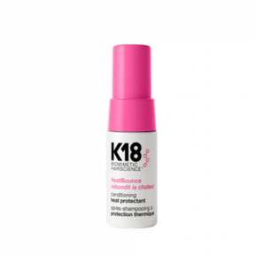 K18 hair care product bottle with pink cap on a white background