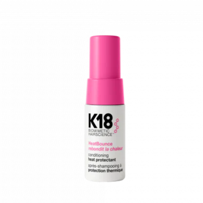 K18 hair care product bottle with pink cap on a white background