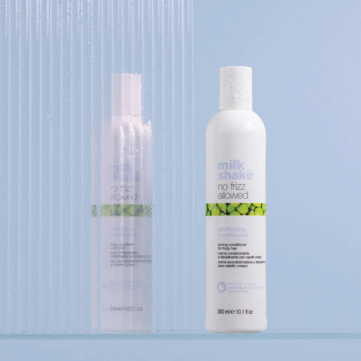 Two bottles of 'milk shea' hair care products on a light blue background