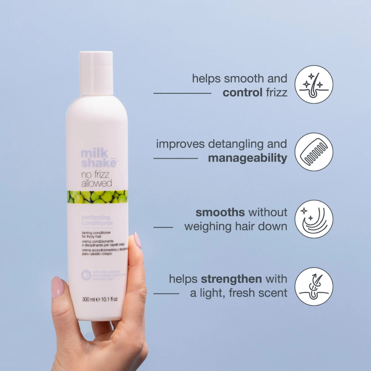 Hand holding a bottle of 'milk shake no frizz allowed' conditioner with text on a light blue background