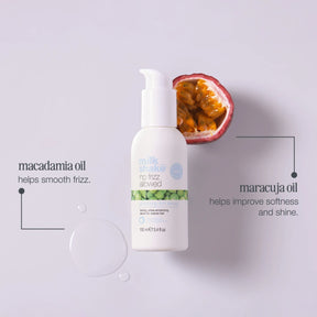 White bottle with green label on a light gray background, featuring text about macadamia and maracuja oils.