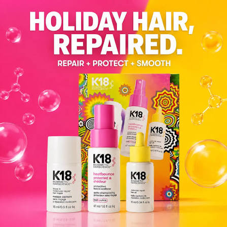 K18 Hair Sciences Holiday Hair, Repair set featuring three hair care bottles (conditioner, repair spray, and smoothing treatment) arranged in front of a colorful patterned box on a vibrant pink and yellow split background with floating bubbles.