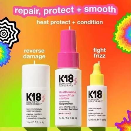 Three K18 Biomolecular haircare bottles on a bright gradient background with colorful abstract flower shapes. The products are white cylindrical bottles with pink and yellow caps, labeled for heat protect, repair, and frizz control.