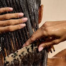 Person washing hair with water, focusing on the action of rinsing.