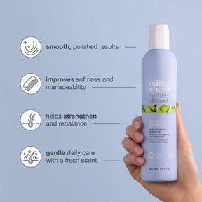 Milk Shake hair product bottle held by a hand with text on a light blue background