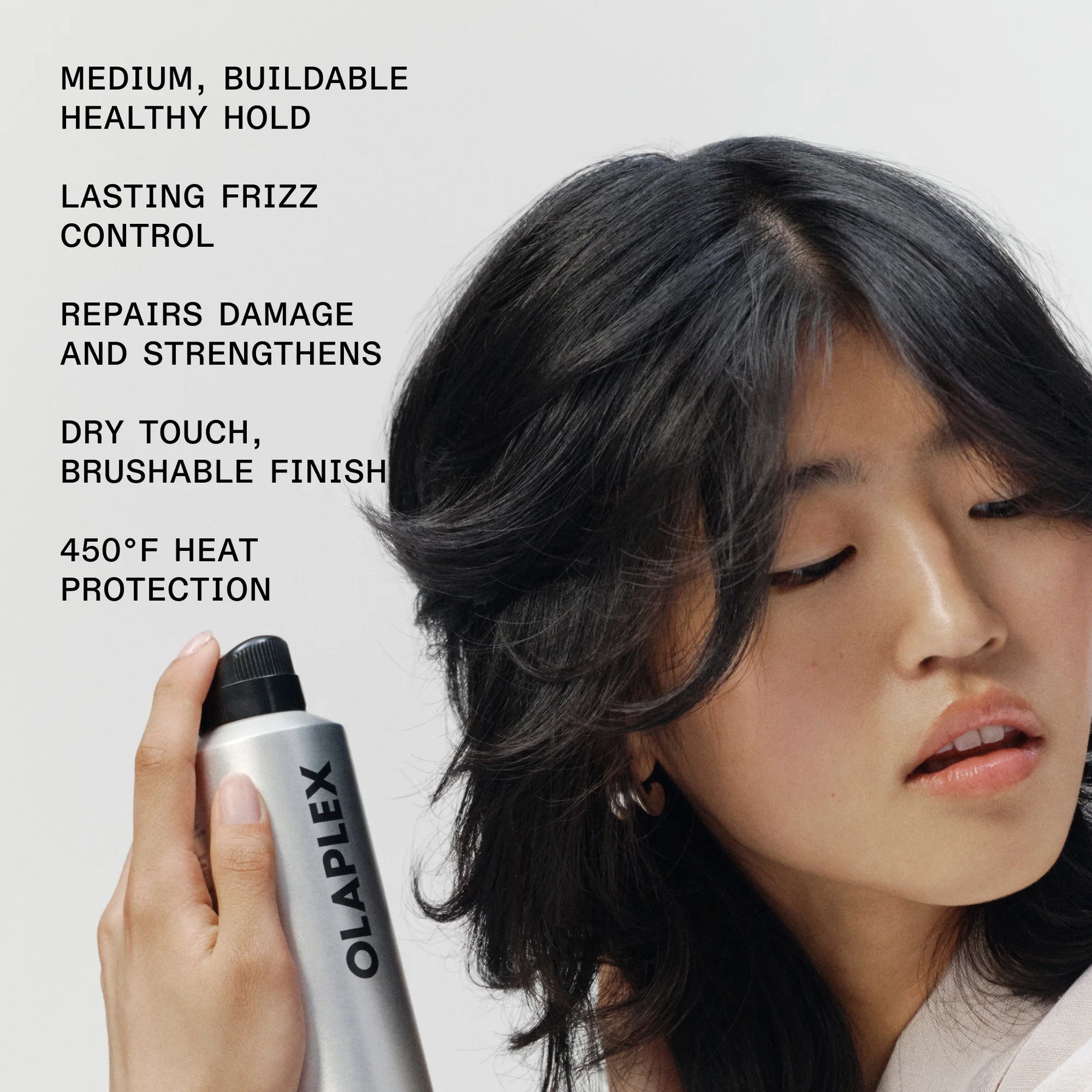 A woman with long black hair holds an Olaplex hair product canister against a light gray background, with product benefits listed in black text on the left side.
