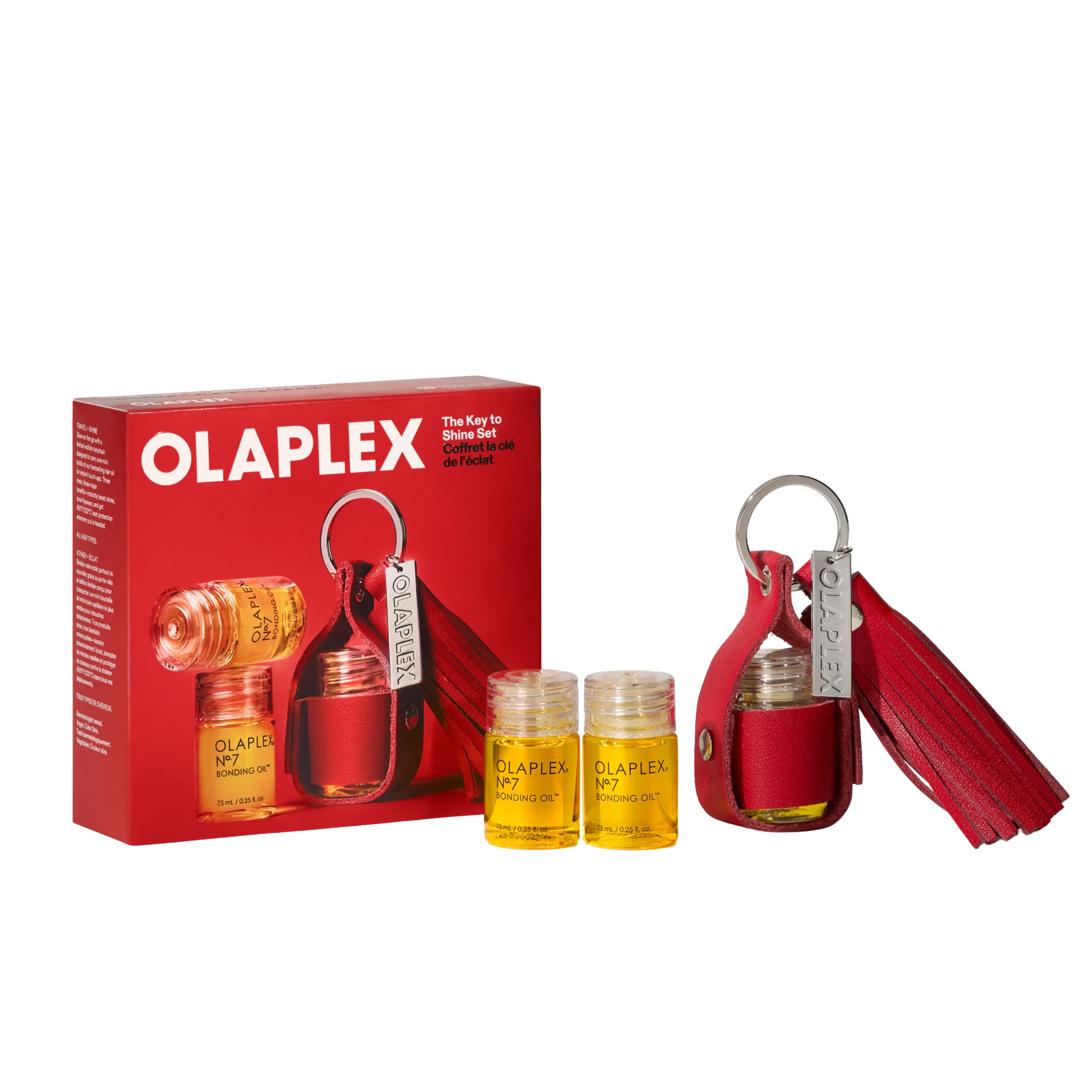 Olaplex The Key to Shine Set, featuring a red leather key case with a tassel, two small clear bottles of yellow oil, and the red retail box on a white background.