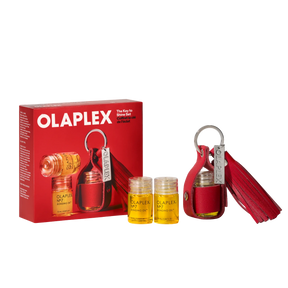Olaplex The Key to Shine Set, featuring a red leather key case with a tassel, two small clear bottles of yellow oil, and the red retail box on a white background.