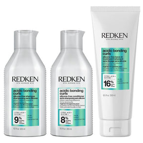 Redken hair care products including shampoo, conditioner, and treatment on a white background