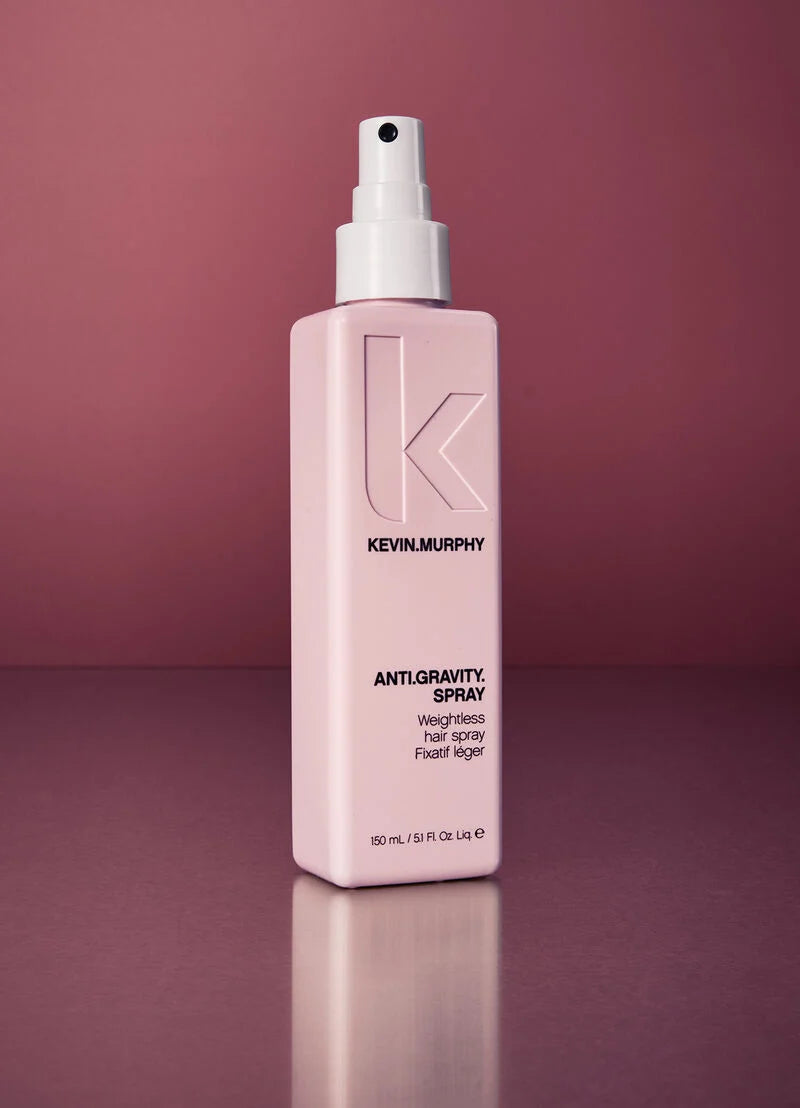 Kevin Murphy Anti-Gravity Weightless Hair Spray in a light pink rectangular bottle with a white spray top, set against a matching pink gradient background.